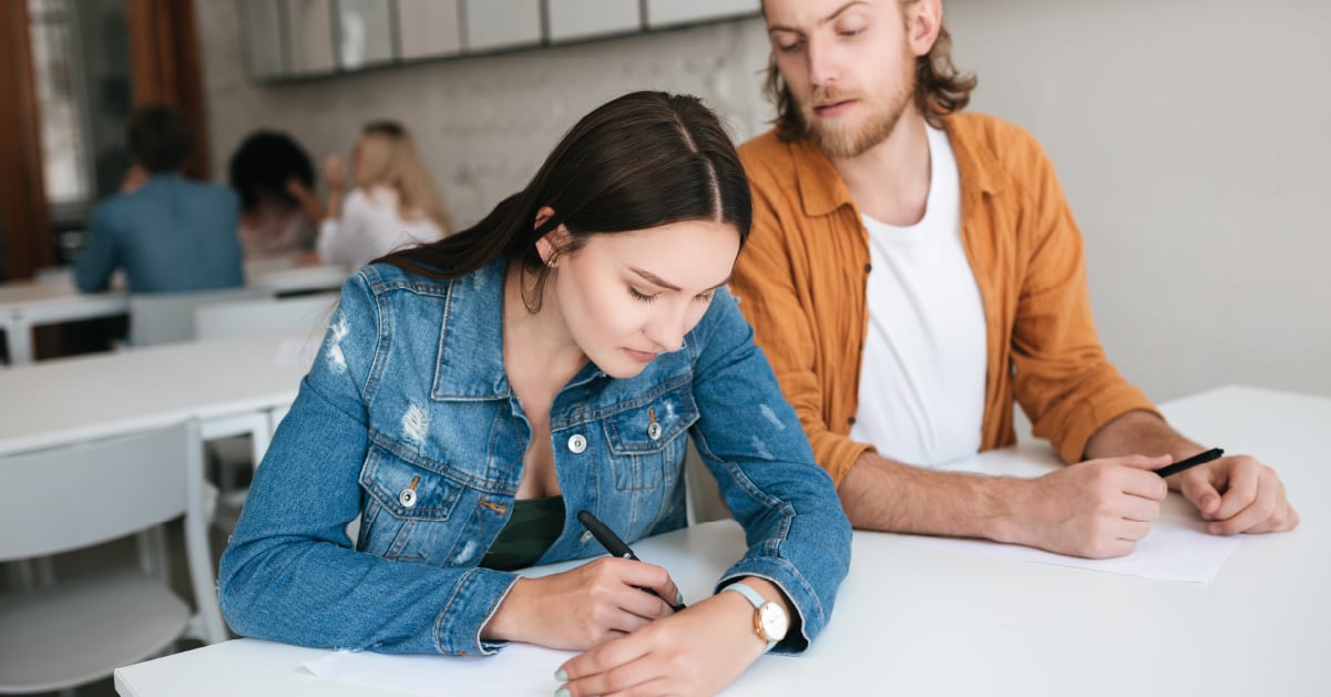 Student looking over shoulder at peer's exam