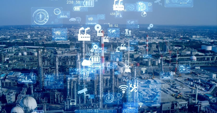 A digital depiction of manufacturing cybersecurity is superimposed over a photo of a large-scale manufacturing facility.