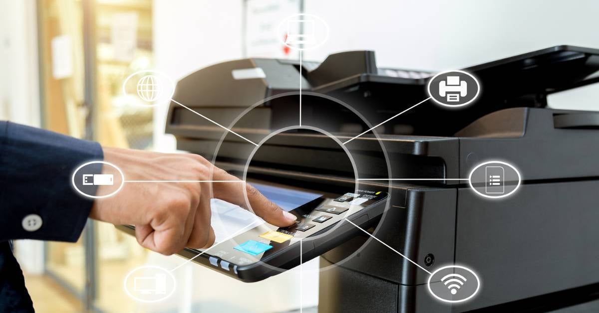 A worker uses a networked business printer with complex capabilities.