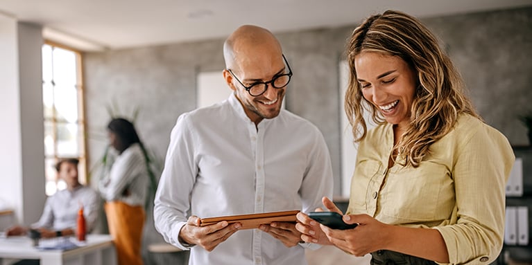 Two individuals smiling at phone