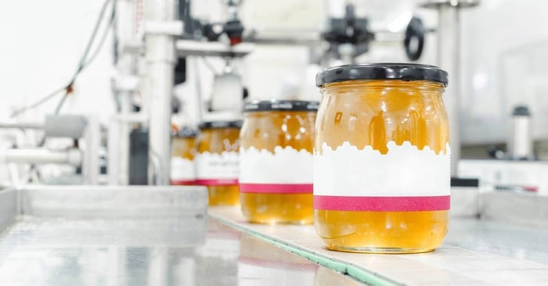 Honey jars move down a production line.
