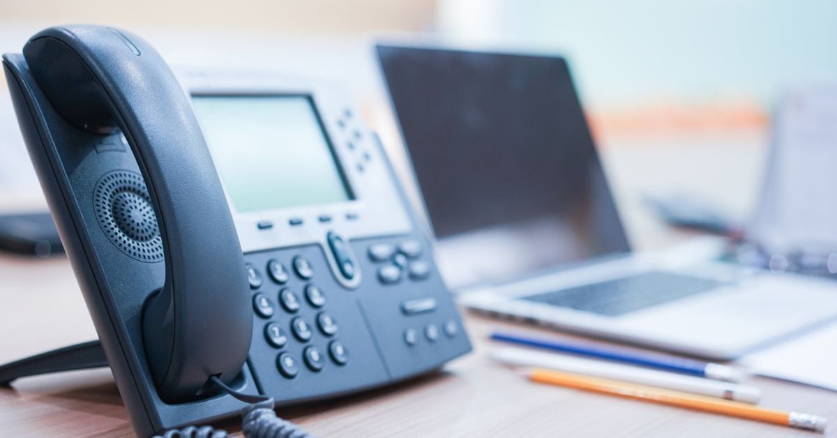 A business phone system on a desk with multiple features and buttons. 