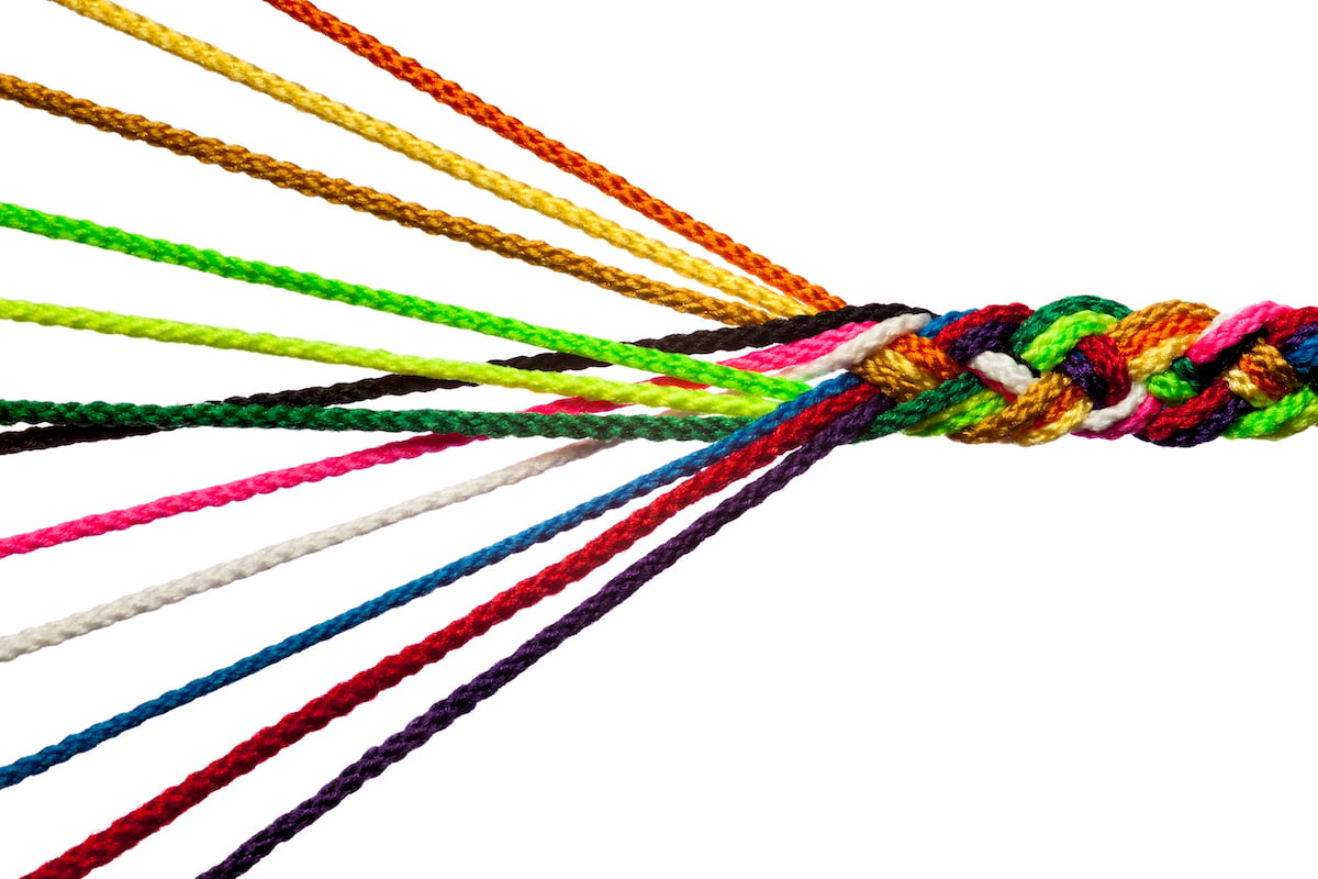 an image of multi-colored threads being woven together