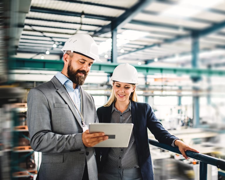 two-professionals-reviewing-tablet-in-industrial-facility