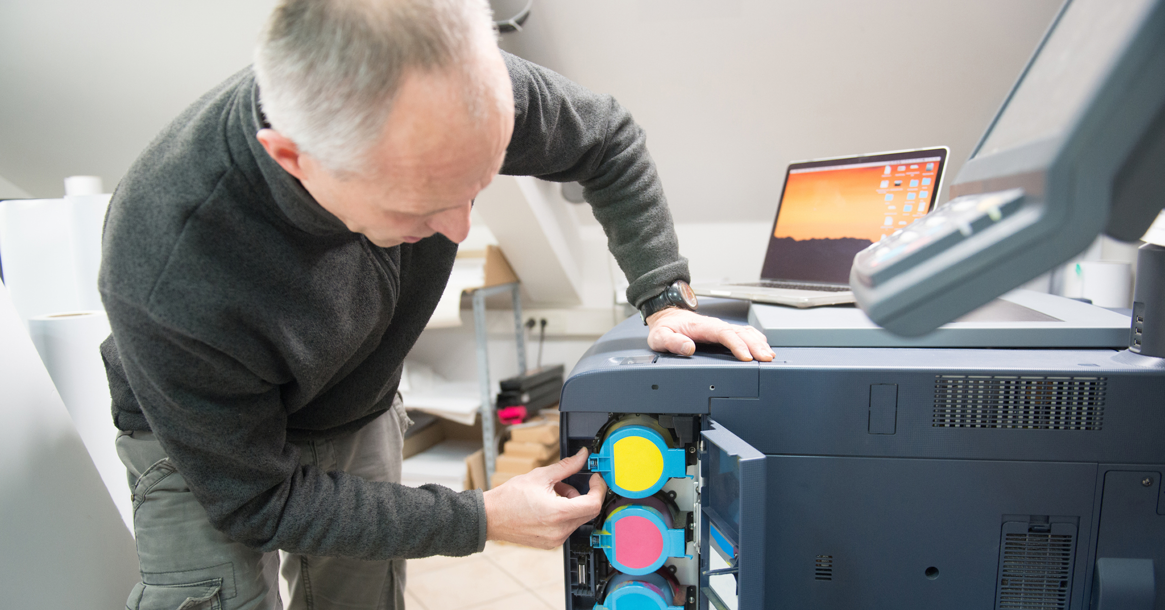 man-changing-toner-cartridges-in-office-printer